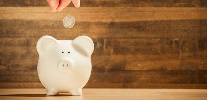 White piggy bank with coin dropping into it