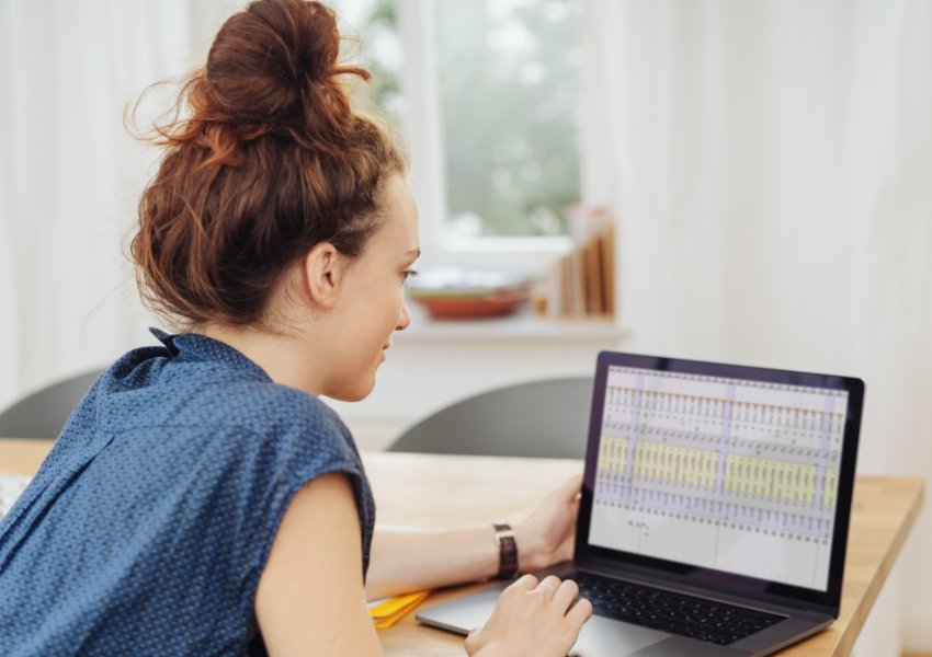 Female business owner looking at a spreadsheet on her laptop