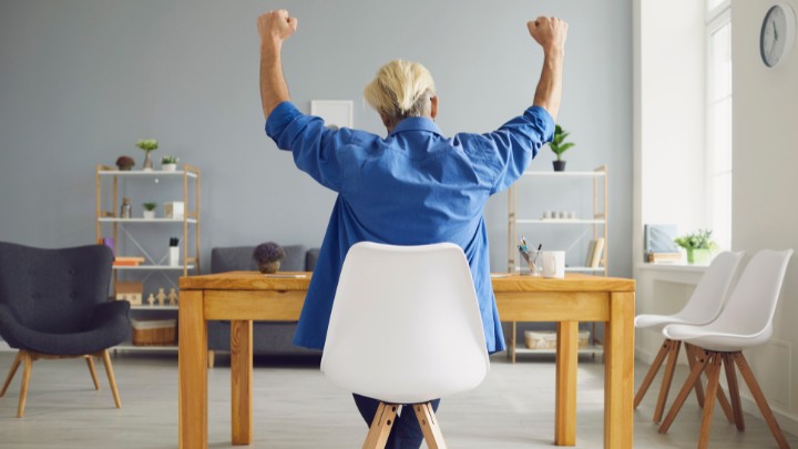 Small business owner celebrating good news at desk