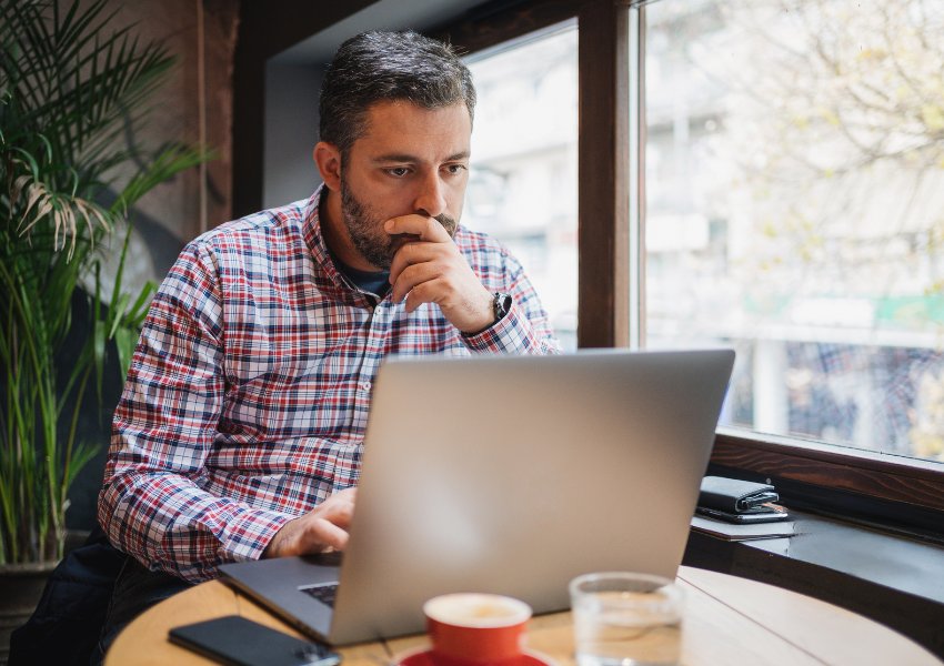 Worried male business owner looking at his laptop